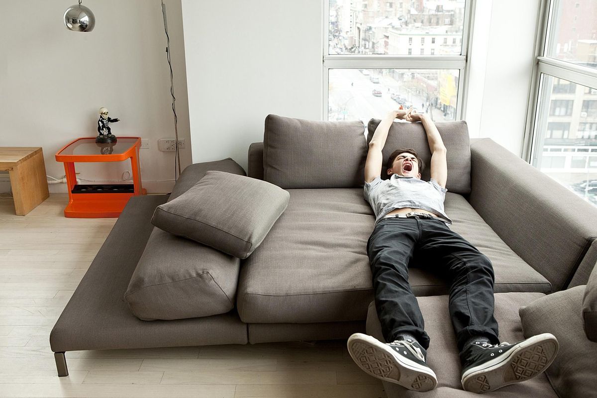 У лени в руках. Ленивый подросток. Подросток лежит на диване. Валяюсь на диване. Диван для подростка.